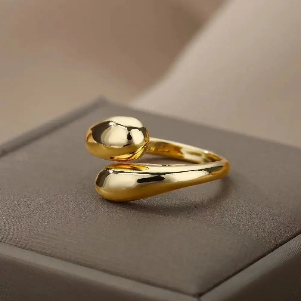 Anillo abierto de acero inoxidable dorado con doble bola geométrica